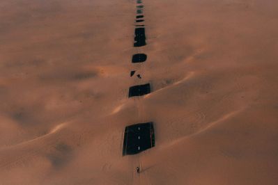 A long road cutting through a vast desert, with parts of it covered in sand. This image visually represents the idea that all paths, even difficult or broken ones, can ultimately lead to God