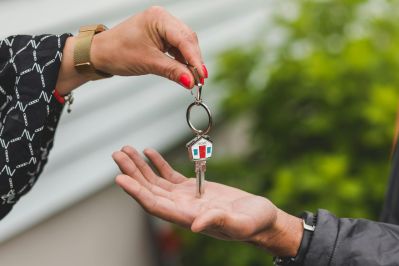 A real estate agent handing house keys to a new homeowner during a home purchase or property closing